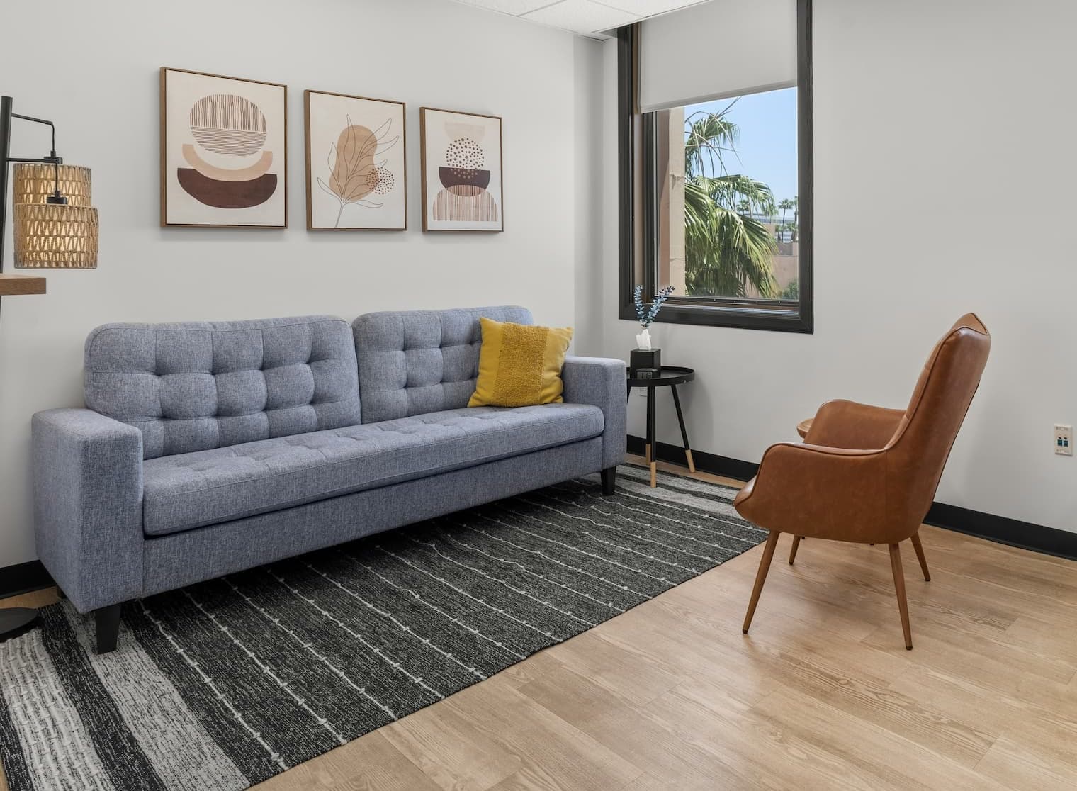 The Pasadena office: a sofa, a leather chair, and light from the window.